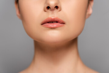 cropped view of female glossy lips isolated on grey