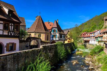 View from the Pont Fortifie bridge to the stream retaining wall and medieval houses in Kaysersberg-Vignoble, Alsace, France