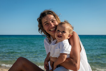 Authentic shot of an young neo mother is keeping on arms her newborn baby boy and both smiling in...
