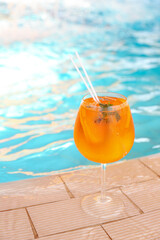 Glass of delicious cocktail near swimming pool. Refreshing drink