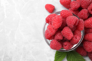 Delicious fresh ripe raspberries on light grey table, flat lay. Space for text