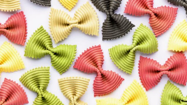 Colored bow tie pasta. Closeup multiple farfalle isolated on white background.