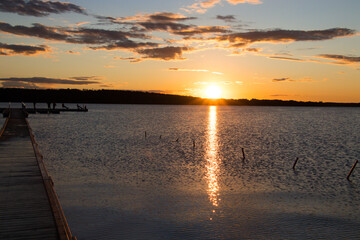 Naklejka na ściany i meble Blue sky and orange sunset over the lake