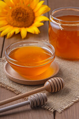 honey in a glass jar on a wooden table.