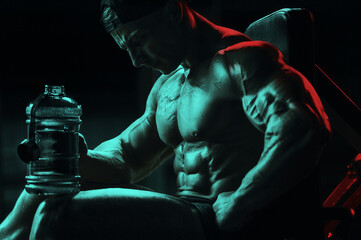 Bodybuilder with protein powder supplements jar