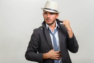 Portrait of handsome bearded Hispanic businessman wearing hat