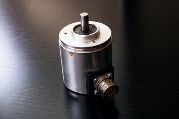 Metal encoder on a black wooden table