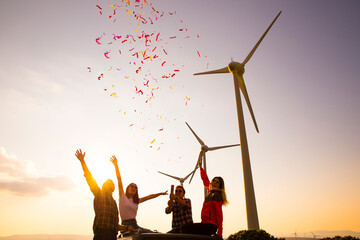 Joyful young friends enjoying the outdoor party together with confetti in nature