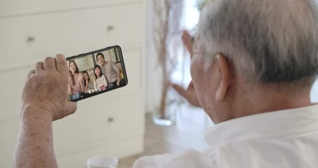 Over shoulder closeup view of asian senior elderly 70s man user holding smart phone watching mobile video calling family in virtual app, older grandparent learn using modern technology gadget concept. - Powered by Adobe