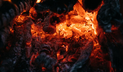 Bright red flames of fire. Ashes and coals. Flames on a dark background. Hot red hot coals, barbecue place. Near the fire.