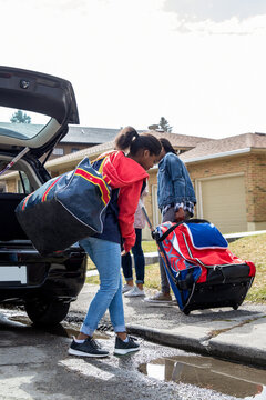 Teen Girl Carrying Sports Bag From Car