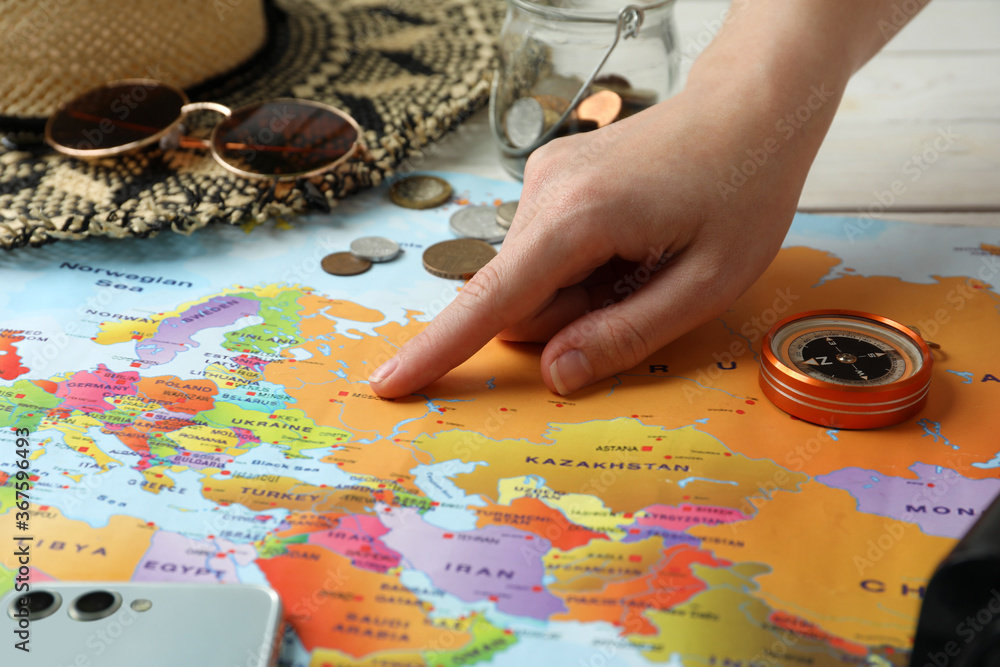 Wall mural Woman with world map at table, closeup. Travel during summer vacation