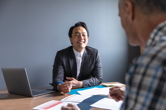 Smiling financial advisor meeting with man in office