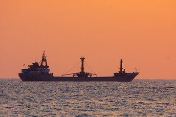Fototapeta premium Freight ship on a sunset horizon