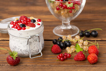 Natural yogurt with chia seeds and berries on a wooden table background. Healthy eating. Diet, weight loss, healthy lifestyle.