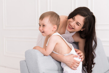 happy family in living room smiling woman and baby boy communicating