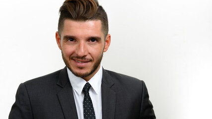 Portrait of handsome bearded Hispanic businessman in suit