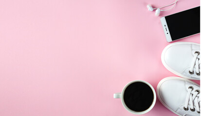 Sports flat lay with coffee, white sneakers, smartphone and earphones on pink background. Fitness concept. Concept healthy lifestyle. Top view. Copy space. Banner.
