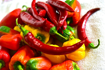 Red and yellow fresh capsicum on a white towel