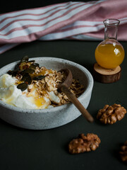 Healthy breakfast - greek yoghurt with cereal, nuts, seeds and honey. 