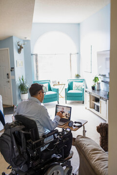 Man in wheelchair on business videocall at home