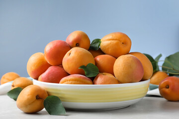 Naklejka na ściany i meble Delicious fresh ripe apricots on white table