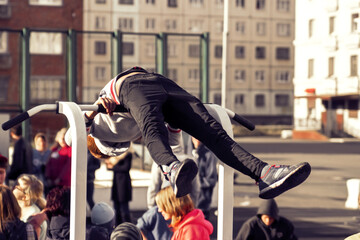 Norilsk, Russia - August, 28, 2016: Little boy doing exercise on the horizontal bar. Street workout. Childrens sport and healthy lifestyle concept.