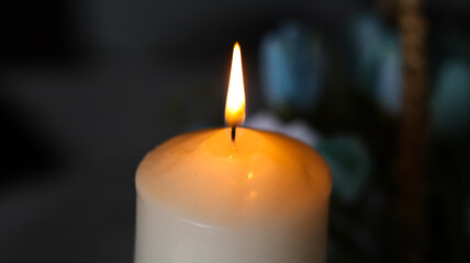 The candle is lit on a dark background.