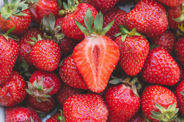 Fresh red ripe organic strawberry background and cuted half closeup 