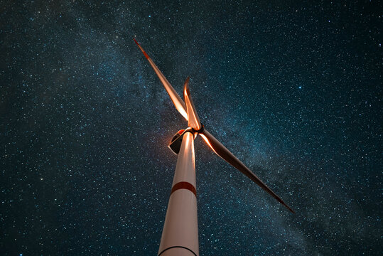 Wind turbine in the night at the stars background. Environment and renewable energy