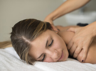 Obraz na płótnie Canvas Young woman having a massage in a spa