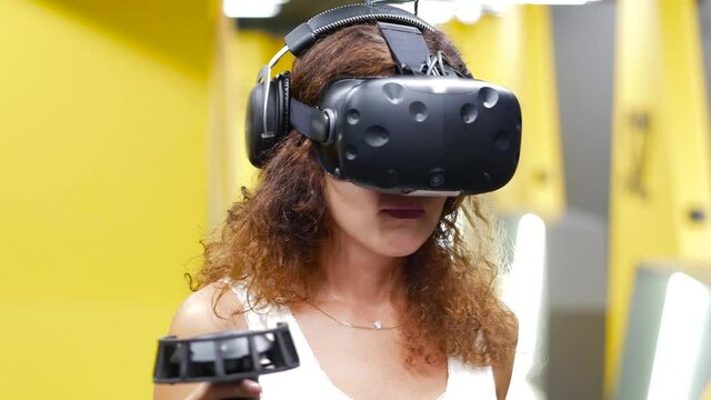 Curvy hair girl playing game with VR glasses