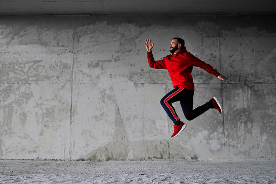 Attractive caucasian runner running fast at urban exterior. © chika_milan