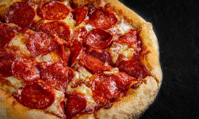 Pepperoni Pizza with Mozzarella cheese, salami, Tomato sauce, pepper, Spices. Italian pizza on Dark grey black slate background