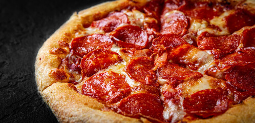 Pepperoni Pizza with Mozzarella cheese, salami, Tomato sauce, pepper, Spices. Italian pizza on Dark grey black slate background