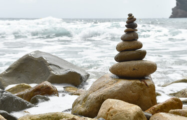 una torre de piedras redondas en una playa del mediterraneo