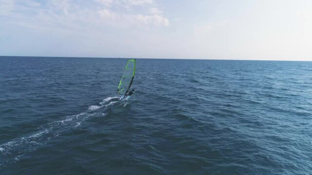A young sexy girl is riding windsurf