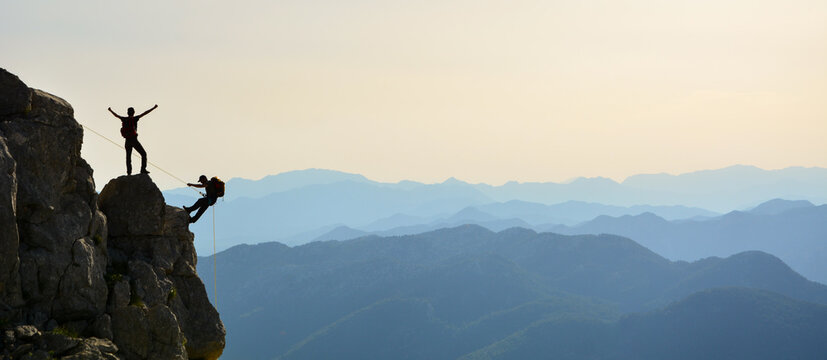 Crazy climbers doing rock climbing in the sunset