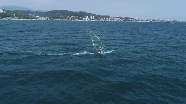 A young sexy girl is riding windsurf