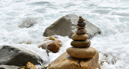 Fototapeta na wymiar una torre de piedras redondeadas en el mar
