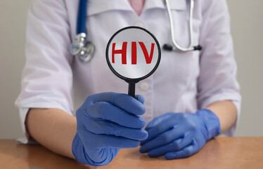Magnifying lens with text acronym word inscription HIV - human immunodeficiency virus - in doctor...