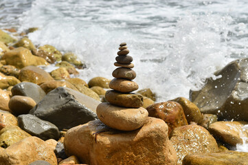 Fototapeta na wymiar a tower of stones on the beach
