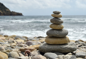 Obraz na płótnie Canvas una torre de piedras redondas en una playa del mediterraneo