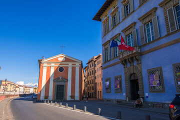 Pisa, Italy - August 14, 2019: The Palazzo Blu and the Santa Cristina Roman Catholic church on the Lungarno Gambacorti in Pisa, Tuscany region, Italy