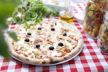 Pizza with artichoke and black olives. Italian cuisine. Traditional Italian pizza. Suggestion to serve a dish. Food background.top view,