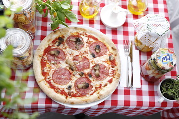 Pizza with salami and mushrooms. Italian cuisine.
Traditional Italian pizza. Suggestion to serve a dish. Food background.