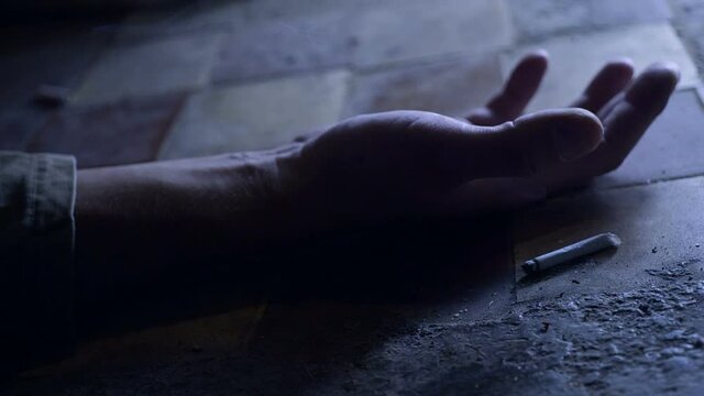 The hand of a person with a smoking cigarette. dying because of smoking . Oncological concept.