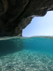 Obraz premium Sea level and underwater photo of caves and rocky nature in famous turquoise pebble beach of Kastani where famous Mamma Mia movie was filmed, Skopelos island, Sporades, Greece