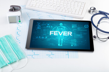 Tablet pc and doctor tools with FEVER inscription, coronavirus concept