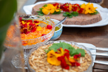Algumas vailhas com vários alimentos em mesa de buffet de festa.